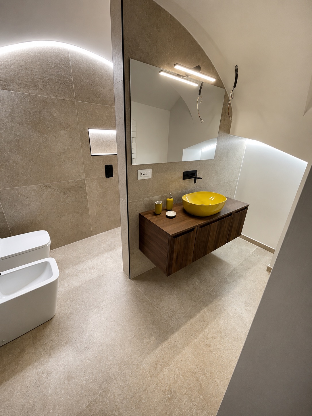 Mobile bagno in legno con lavabo da appoggio giallo e specchio retroilluminato